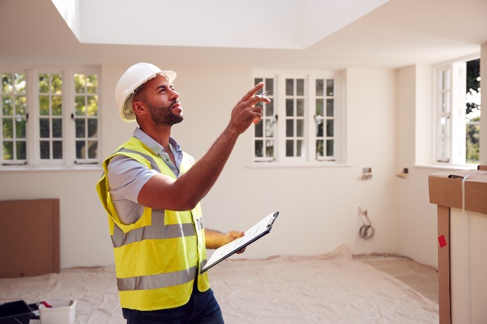 Chartered building surveyor in a house pointing out hugely problematic structural issues which will lead to the house's eventual demolition, rendering its occupants homeless