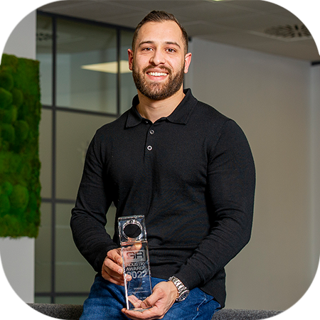 Lead Consultant Cameron DeWit holding his Global Recruiter award